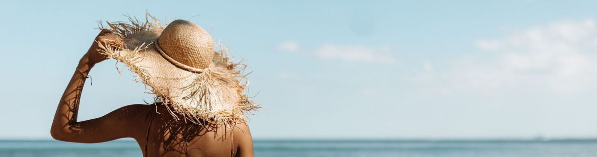 Woman with a tan sitting on the beach in the shade