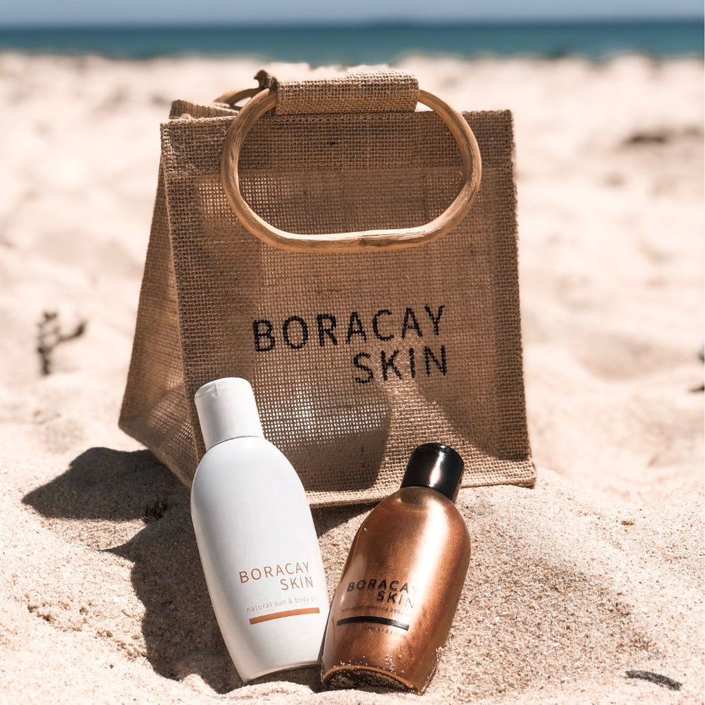Boracay Skin jute bag on the beach with body oil products resting against the jute bag