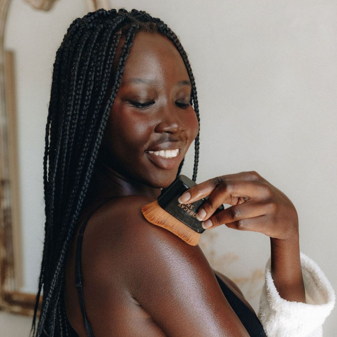 Model applying body oil on shoulders with Boracay Skin kabuki brush
