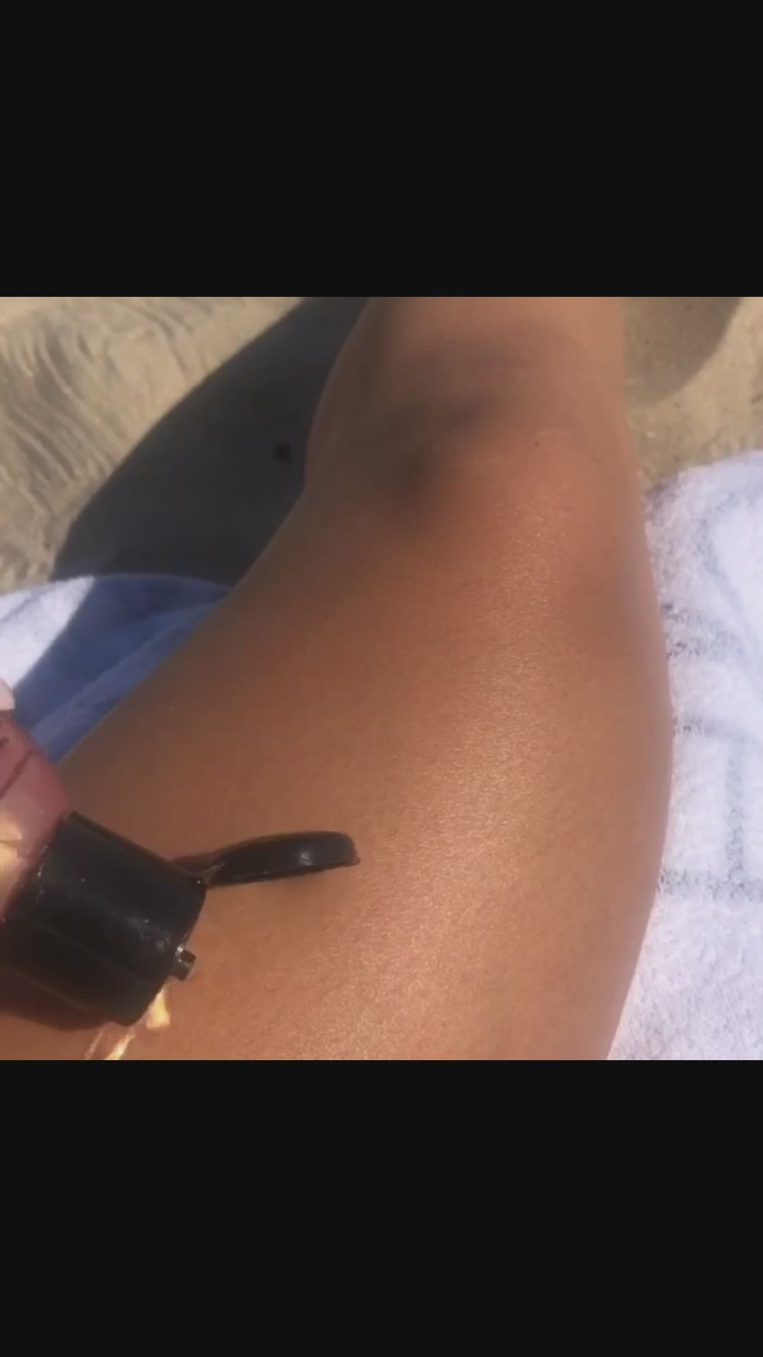 Video showing application of Boracay Skin Rose Gold Shimmering Body Oil on leg of a model while at the beach